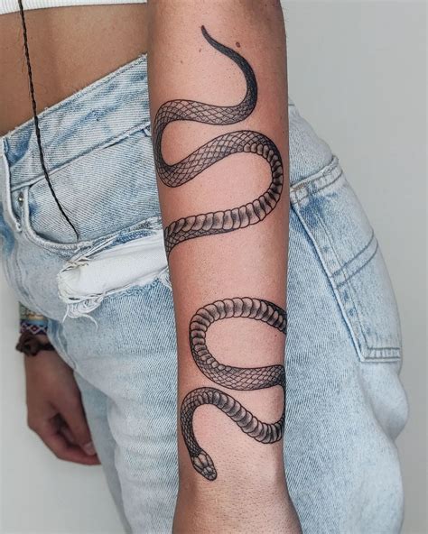 Snake wrapping around arm tattoo